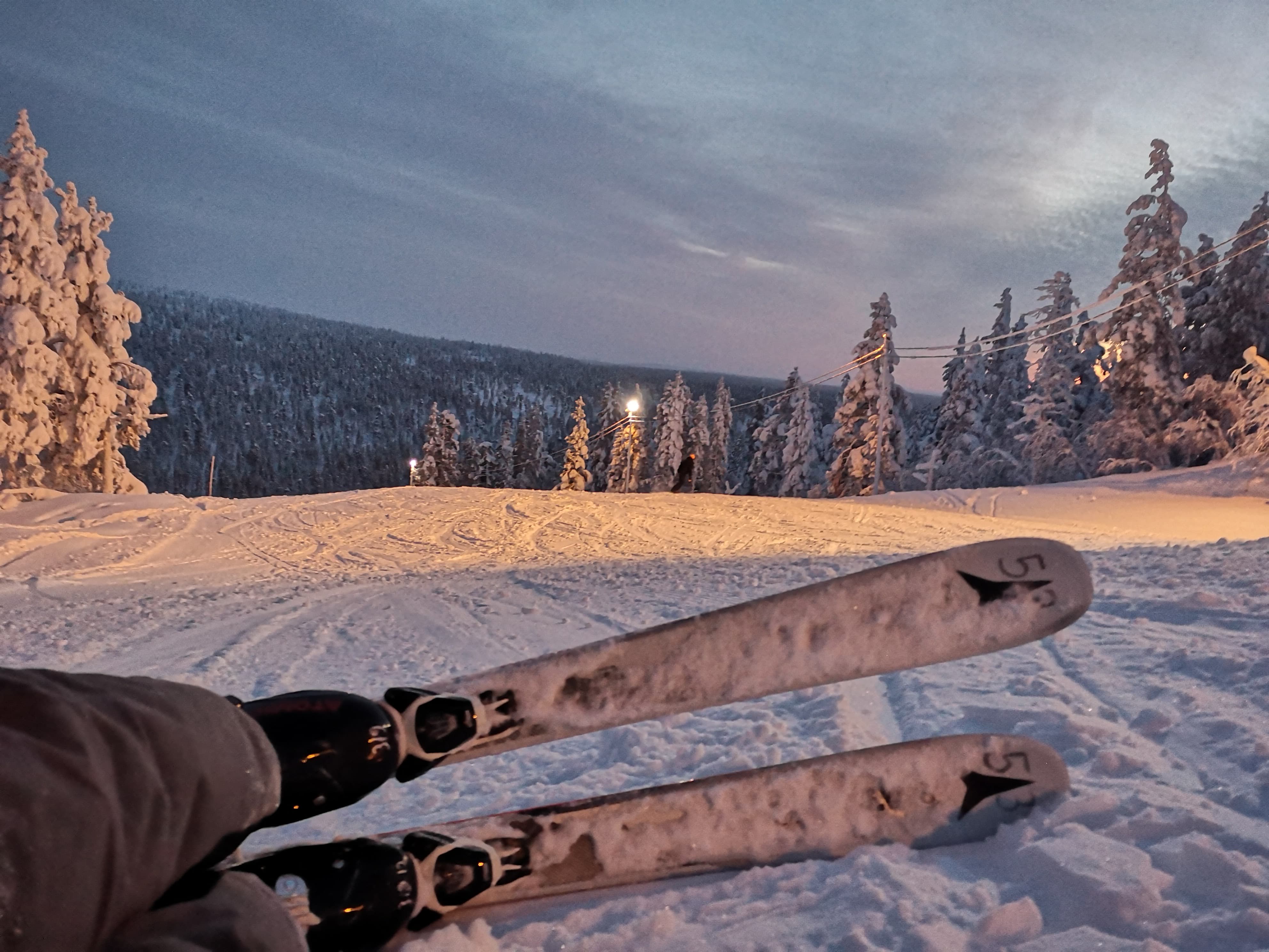 sitting in snowshoes at sunset
