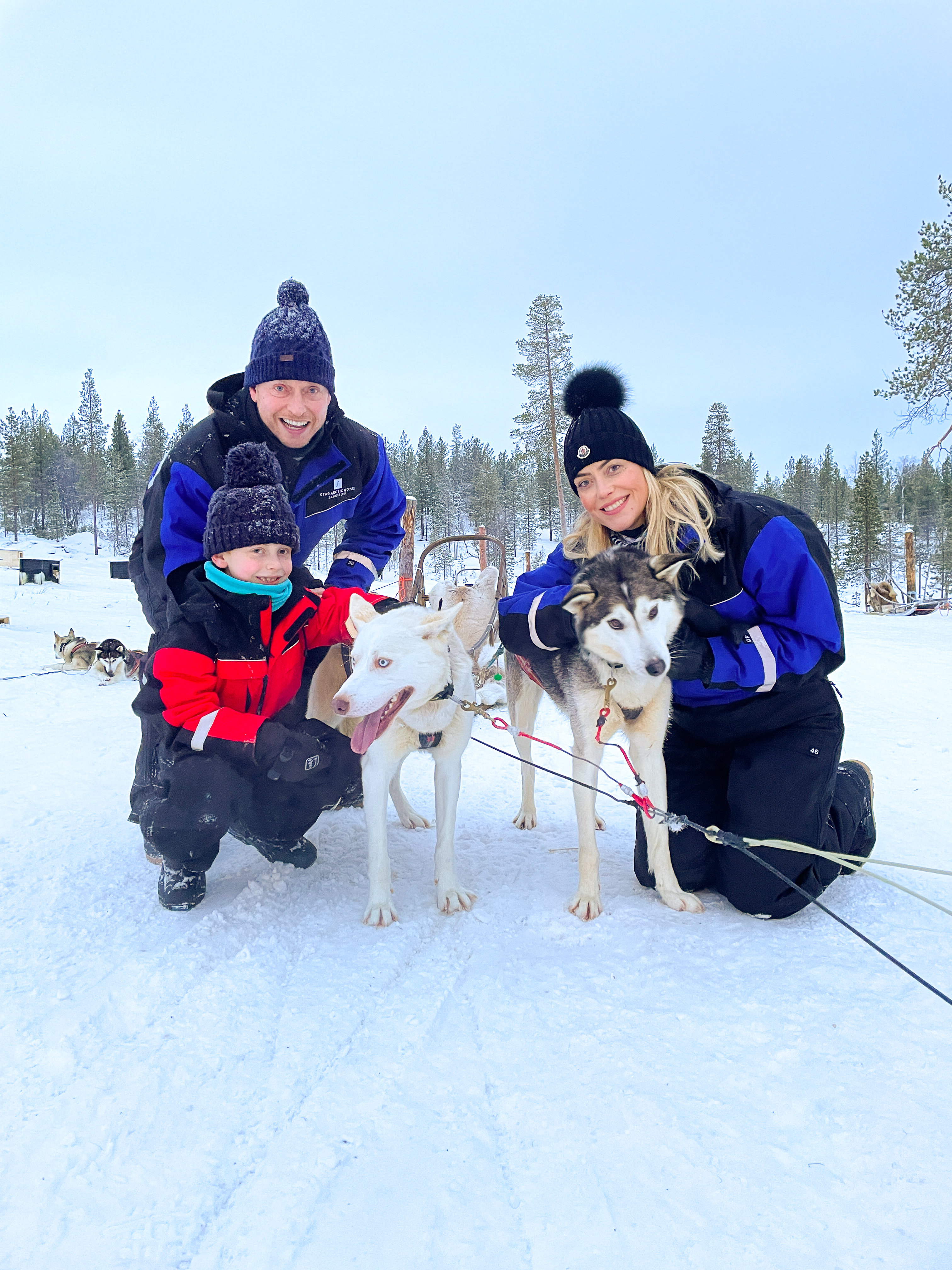 Family posing with huskies